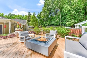 A modern outdoor patio with a fire pit and seating area.